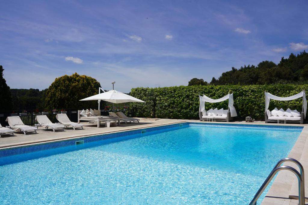 Infinity pool with loungers and cabanas at Villa Pesce