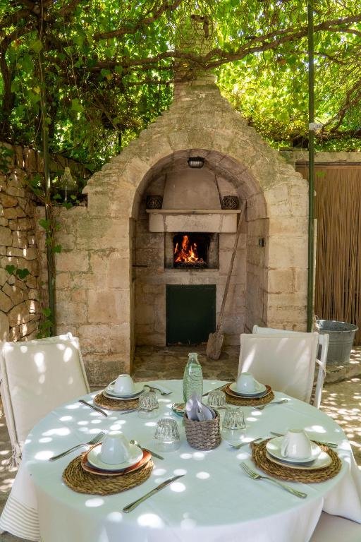 Breakfast table under the pergola beside a stone oven at Villa Pesce