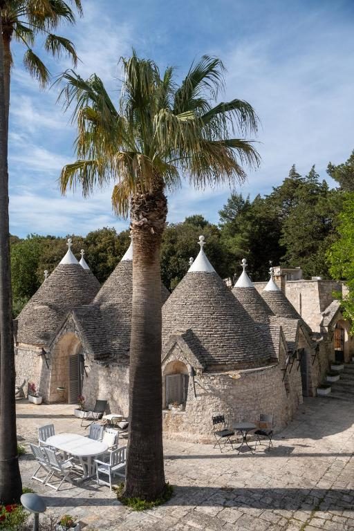 Trulli and palm tree at Villa Pesce in Selva di Fasano